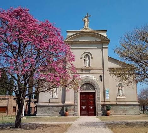 Iglesia de Colonia Caroya con un lapacho en flor